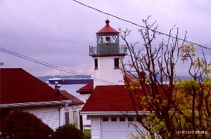 A ship passes by the lighthouse.