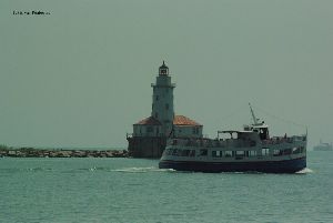 One of the many harbor cruises pass the lighthouse.