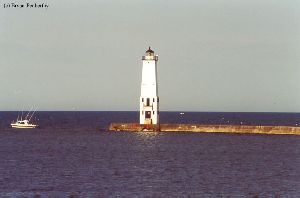 A boat passes by the lighthouse.