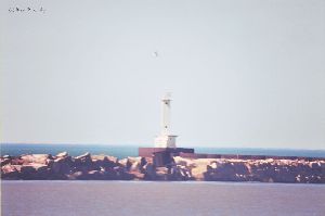 Lighthouse with rocks in photo - distant.
