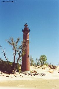 The lighthouse as it stands its post on the beach.