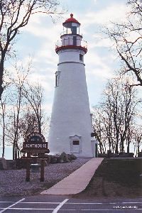 Lighthouse with sign in foreground.