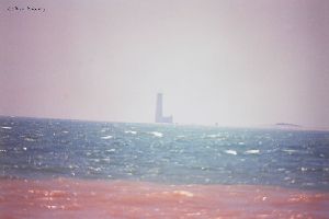 Distance shot of lighthouse out in lake.