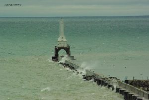 Waves crash over the pier.
