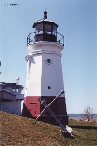 Lighthouse with anchor in front of it.