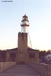 The lighthouse towers over an outbuilding.