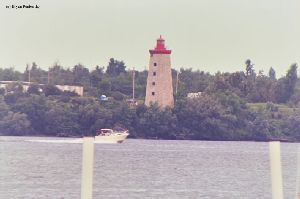 A boat races by the Windmill Point light.